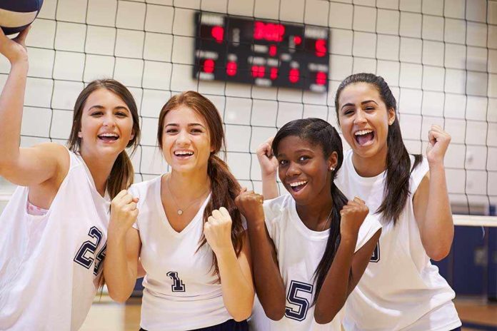 shutterstock_199091366.jpg Four female volleyball players celebrating in a gymnasium