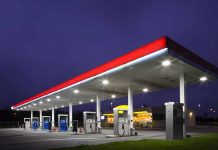 A gas station at night with illuminated fuel pumps and a convenience store