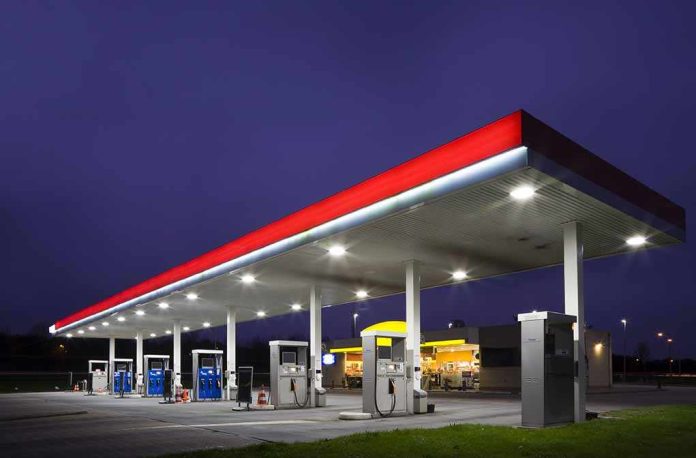 A gas station at night with illuminated fuel pumps and a convenience store
