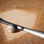 Baseball’s New Tech Fails: Manager Ejected A baseball bat and ball resting on a baseball diamond