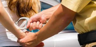 Delta Force Insider ARRESTED — Shocking BETRAYAL Officer handcuffing a person near a car.