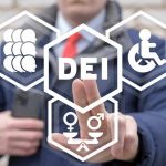 Person pointing at DEI symbols on glass.