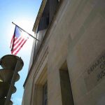 American flag at Department of Justice building exterior.