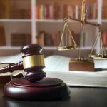 Gavel, law book, and scales in a library.