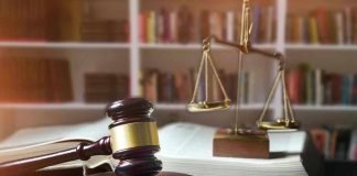 Gavel, law book, and scales in a library.