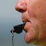 Close-up of a sports coach blowing a whistle