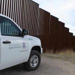 Trumps Top Chief QUITS – Mystery Deepens! Border protection vehicle near a large metal fence.