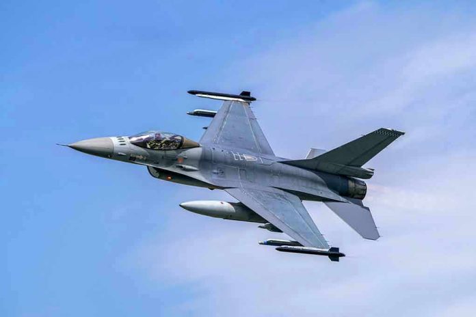 Jet fighter flying through clear blue sky.