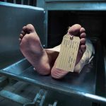 Body on morgue tray with toe tag