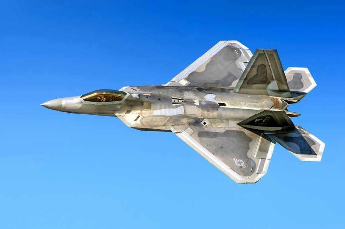 514318066 Fighter jet in flight against a clear blue sky.