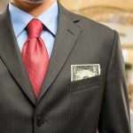 Minimum Wage Change ROCKS Local Businesses! Man in a suit with a red tie and money peeking from his pocket