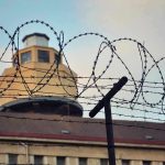 Ex-President Receives 30-Year Prison Sentence! Barbed wire in front of a prison tower.