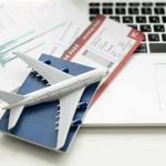 Four Letters You DON’T Want To See on Your Boarding Pass! A model airplane on a blue passport next to a laptop and boarding pass