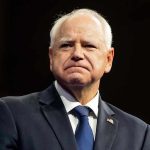 Man in suit with a U.S. flag pin.