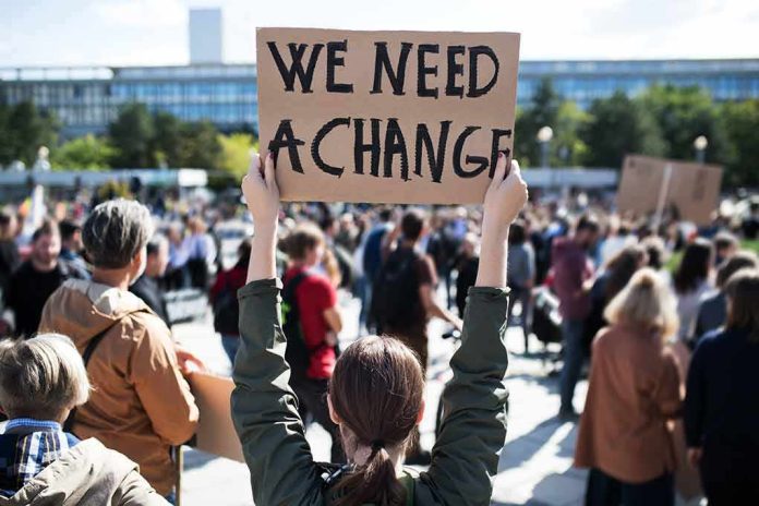 Person holding protest sign above head at a crowded rally