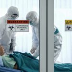 Doctors Say Outbreak Spreading Too Fast – Call For International Help Healthcare workers in hazmat suits treat a patient in a quarantine room