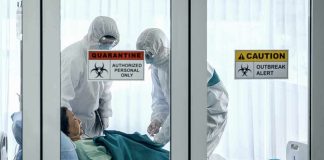 Doctors Say Outbreak Spreading Too Fast – Call For International Help Healthcare workers in hazmat suits treat a patient in a quarantine room