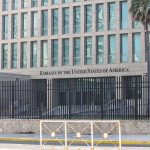 Embassy building behind tall black security fence