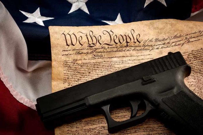 shutterstock_1034579311 Handgun on U.S. Constitution with American flag backdrop