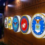 Captured American Marine’s Condition WORSENS! Military department seals displayed on a wall