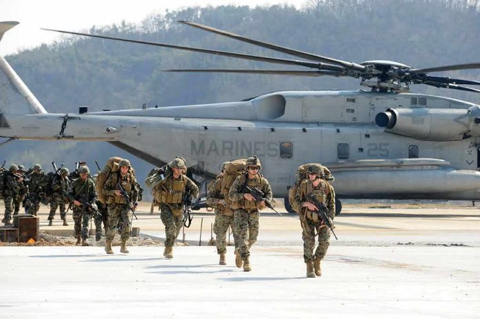 shutterstock_1123252001 Soldiers disembark and walk past a large military helicopter