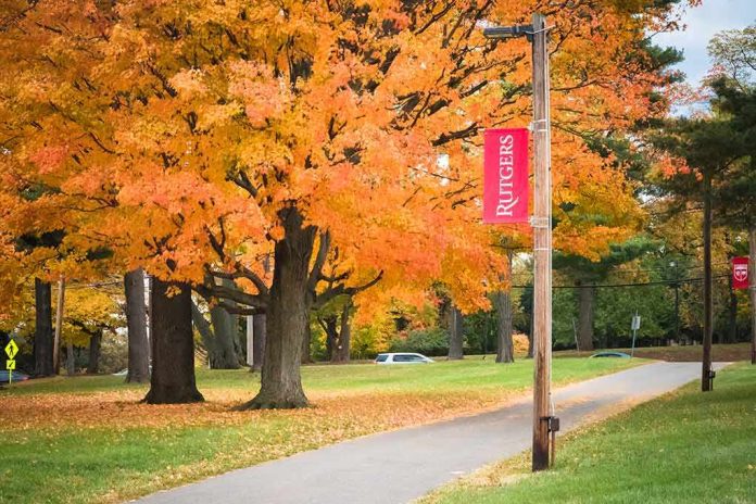 Autumn trees along a campus pathway with red banners on poles