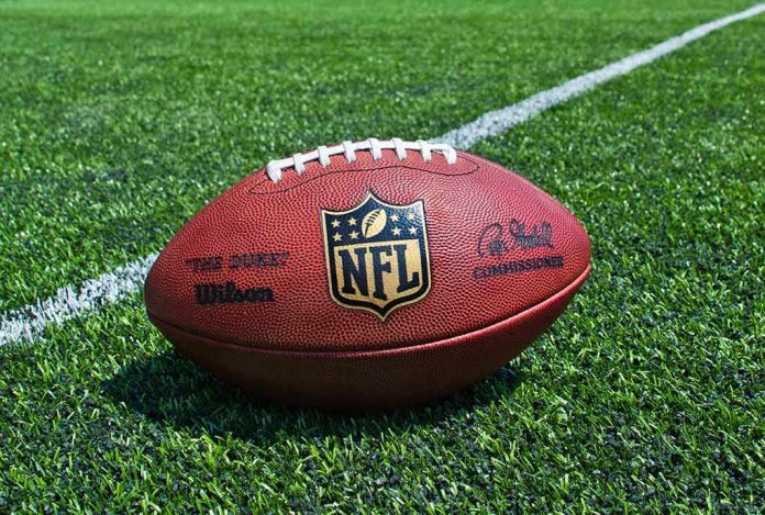 American football on a turf field near a white yard line