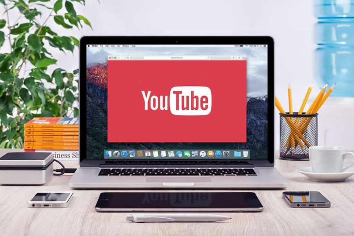 293731811-1 YouTube logo on a laptop screen on desk.