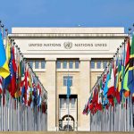 President Torches UN: Calls It ‘Useless’ and Bloated United Nations building with numerous national flags outside.