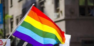 Kim Kyung-tae with others waving a rainbow pride flag at a street parade