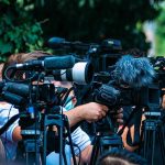 Judge Tosses Key Video During Kirk Murder Trial! TV news cameras crowding together at an outdoor event