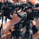 National Guard Member Shoots 20-Year-Old Armed Man television cameras on tripods at a media event