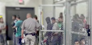 Senate Candidate Would Trade Five Americans for One Illegal Detention facility with people behind chain-link fence and officer nearby