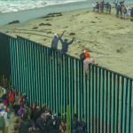 State Dept. Warns Americans To Avoid Region People climbing a tall beachside border fence