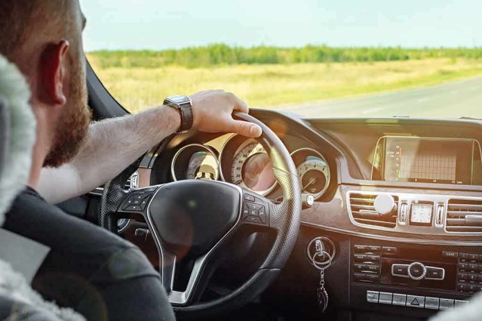 Driver's hands on steering wheel of car interior