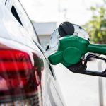 Stealth Gas Hikes Hit 26 States! Green fuel nozzle pumping gas into a white car