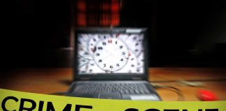 crime scene tape in front of a blurred laptop