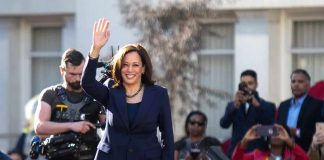 Red-State Dems to Harris: Stay Away woman in navy suit waving at outdoor event