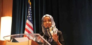 Woman in hijab speaking at a podium