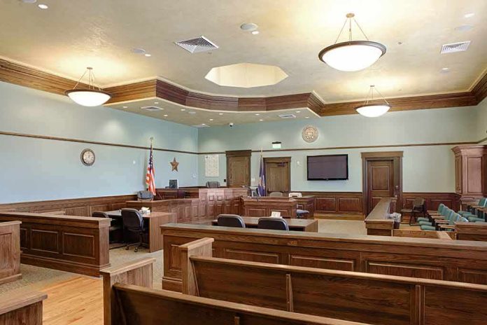 shutterstock_1349439551-3 Empty courtroom with wooden benches and judge's bench