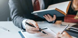 Hands signing a legal document at a desk