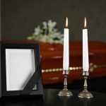 Memorial frame and candles with a casket in the background