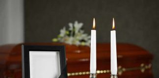 Memorial frame and candles with a casket in the background