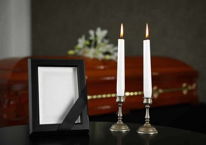 shutterstock_1480856555 Memorial frame and candles with a casket in the background