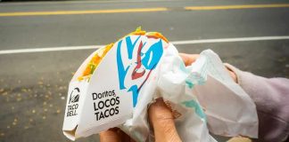 Hands holding a Taco Bell Doritos Locos Tacos