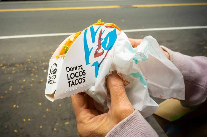 shutterstock_1545877553 Hands holding a Taco Bell Doritos Locos Tacos
