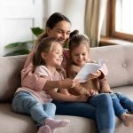 Murder Horror: Mom Vanishes, Ex Surrenders to Police Woman reading a book with two young girls on a sofa