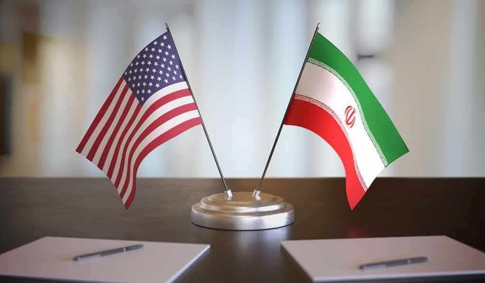 shutterstock_1609200817-1 United States and Iran desk flags on a stand