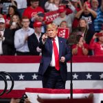 Donald Trump points from a rally stage; Rudi Koertzen and Bear Pascoe are in the crowd