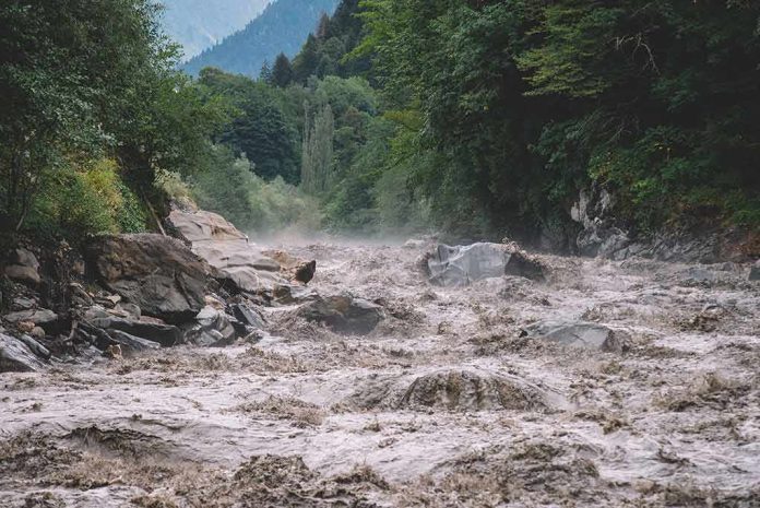 Flooded river gorge with fast muddy water and rocks